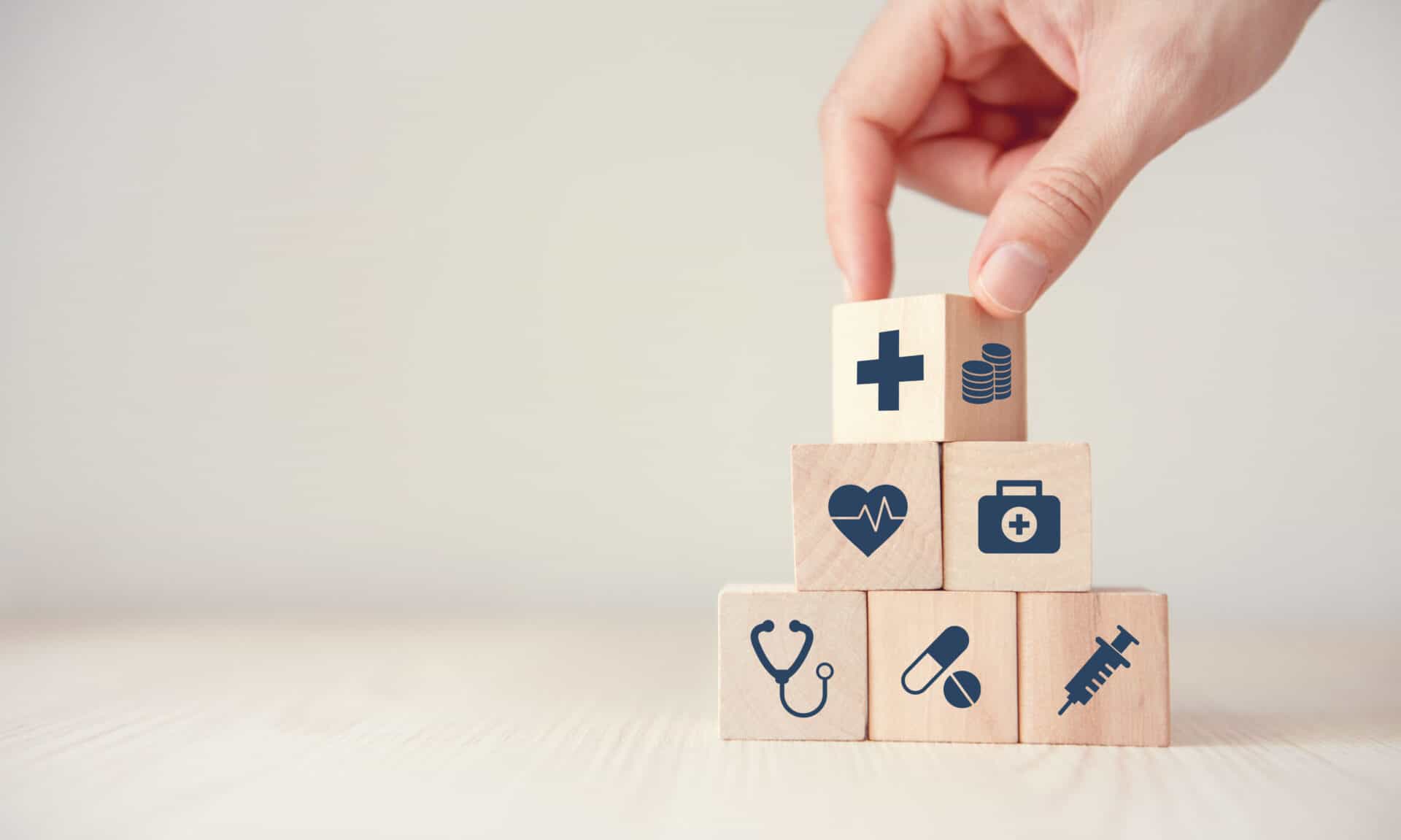 Health Insurance Concept, Hand arranging wood cube stacking with icon healthcare medical on wood background, copy space, financial concept.