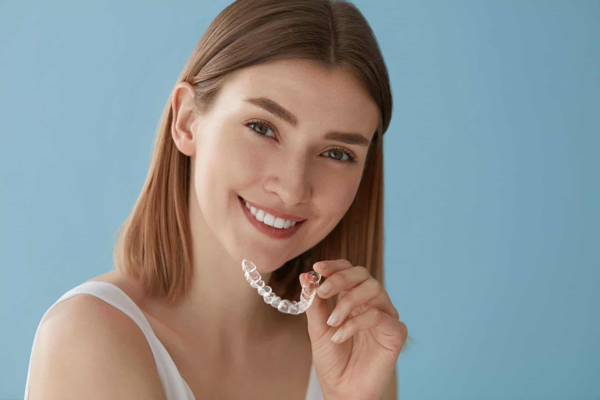 Teeth whitening. Woman with healthy teeth using removable braces