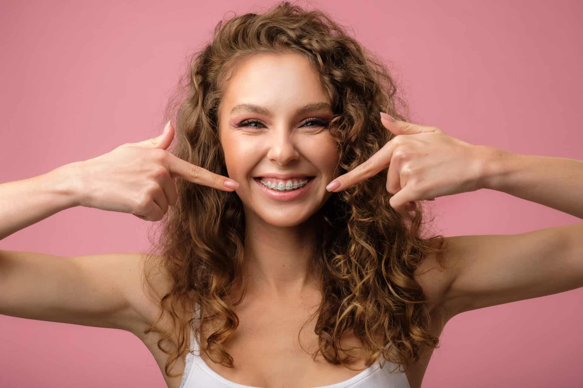 Happy girl with curly hair and dental braces